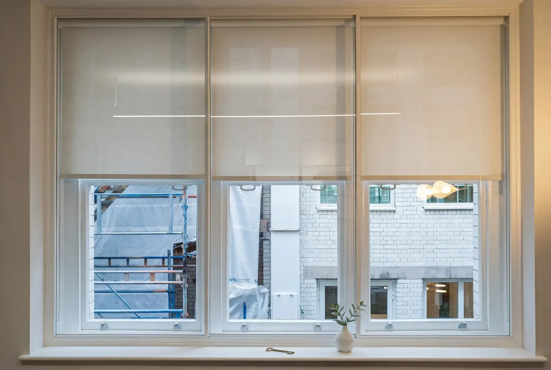 Three-pane window with secondary glazing fitted behind roller blinds in a refurbished London building