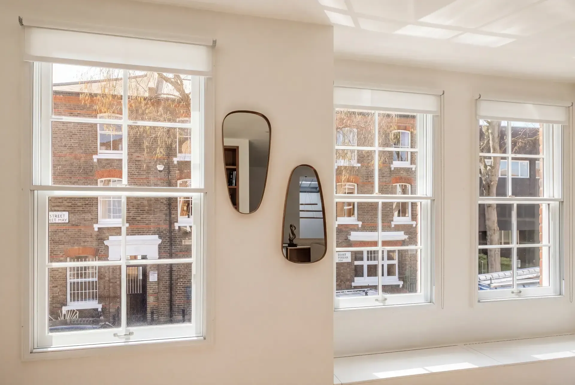 Bright corner room with three sash windows fitted with slimline secondary glazing and roller blinds