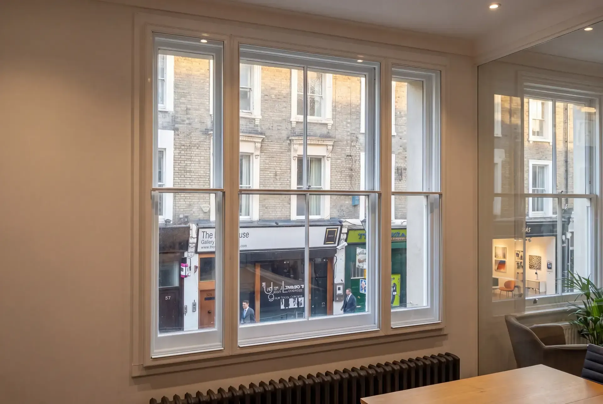 Office meeting room with a three-pane sash window fitted with secondary glazing overlooking a London street
