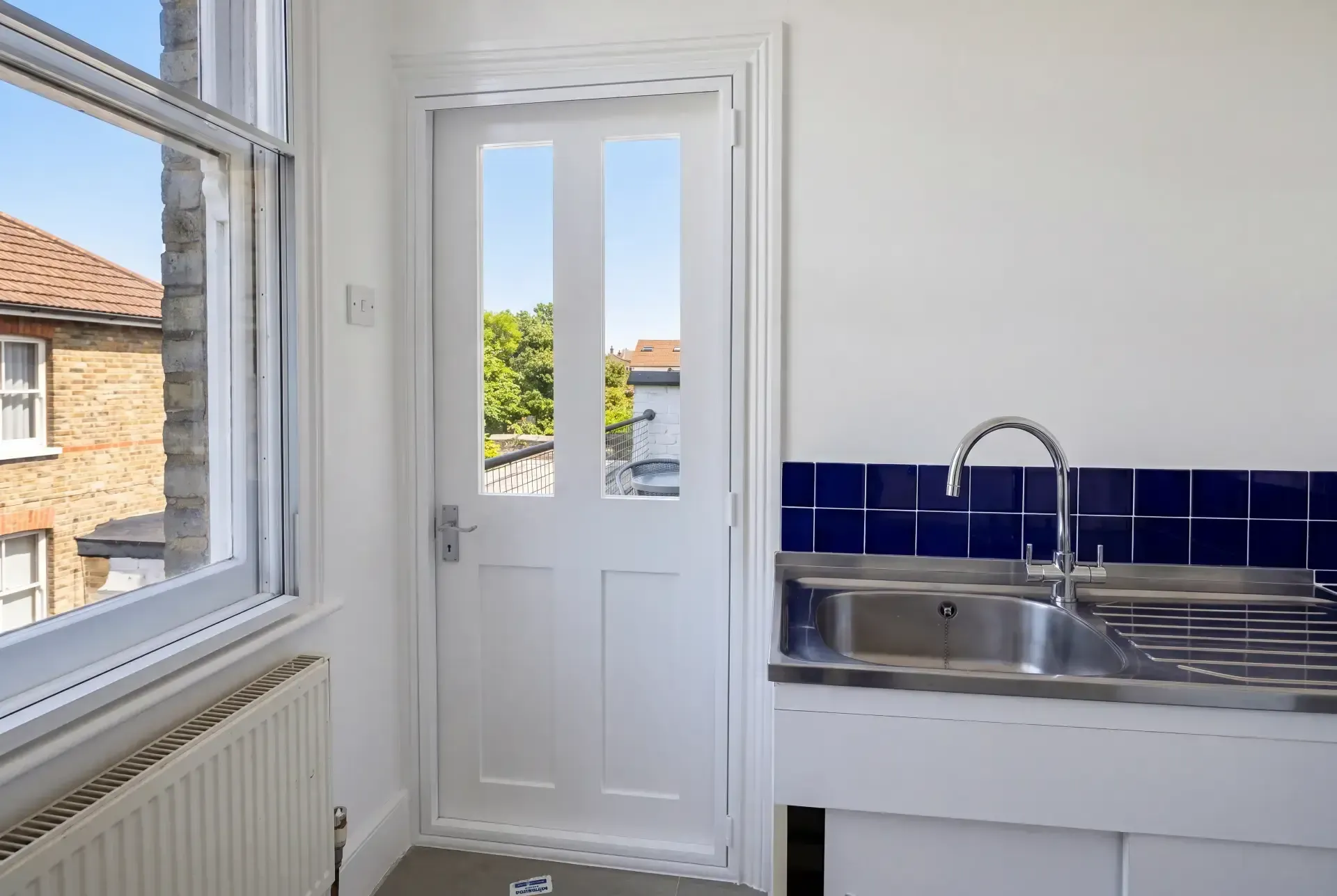 Hinged secondary glazing unit fitted to a glazed roof-terrace door beside a kitchen window