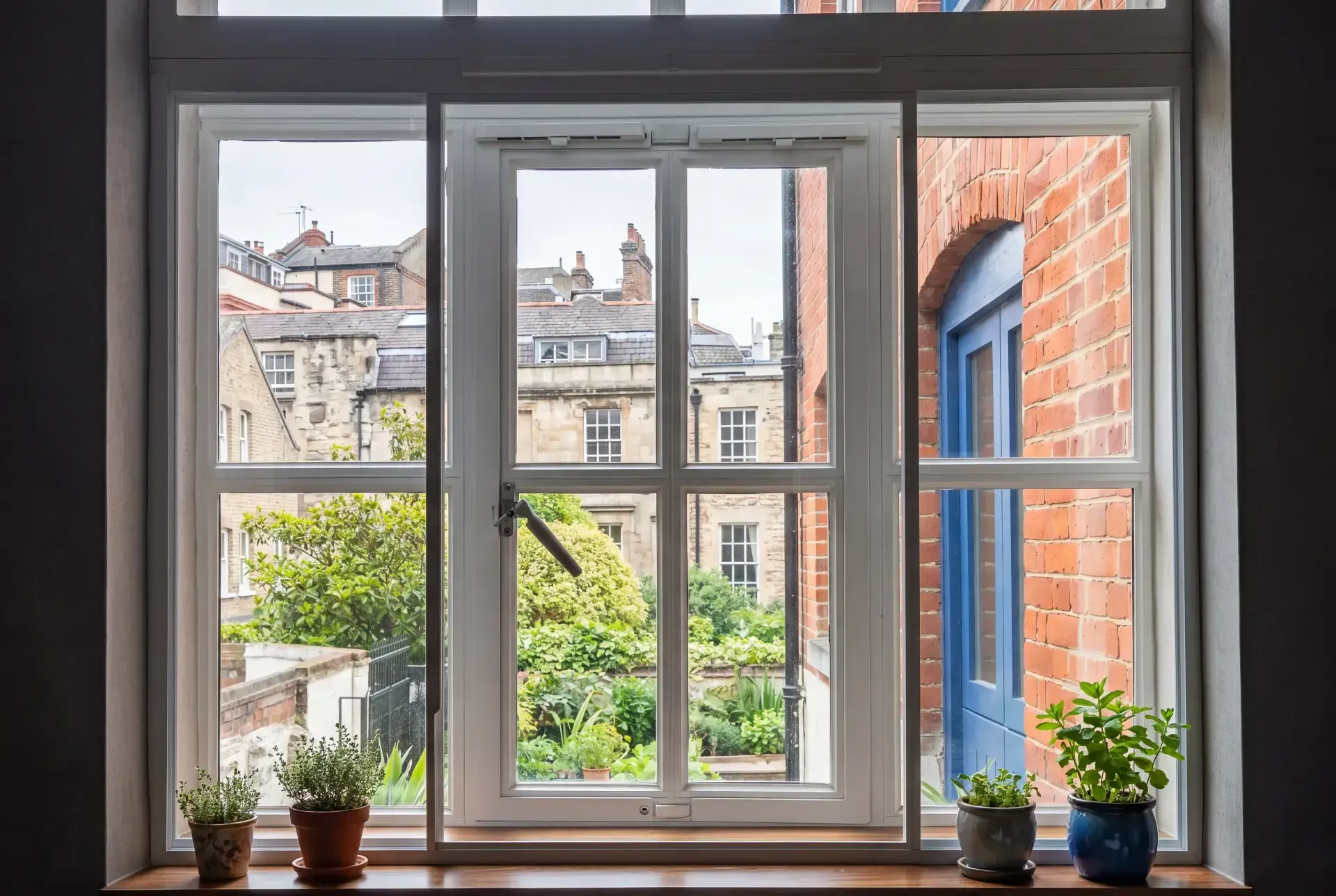 Casement window with slimline secondary glazing looking onto a walled London garden