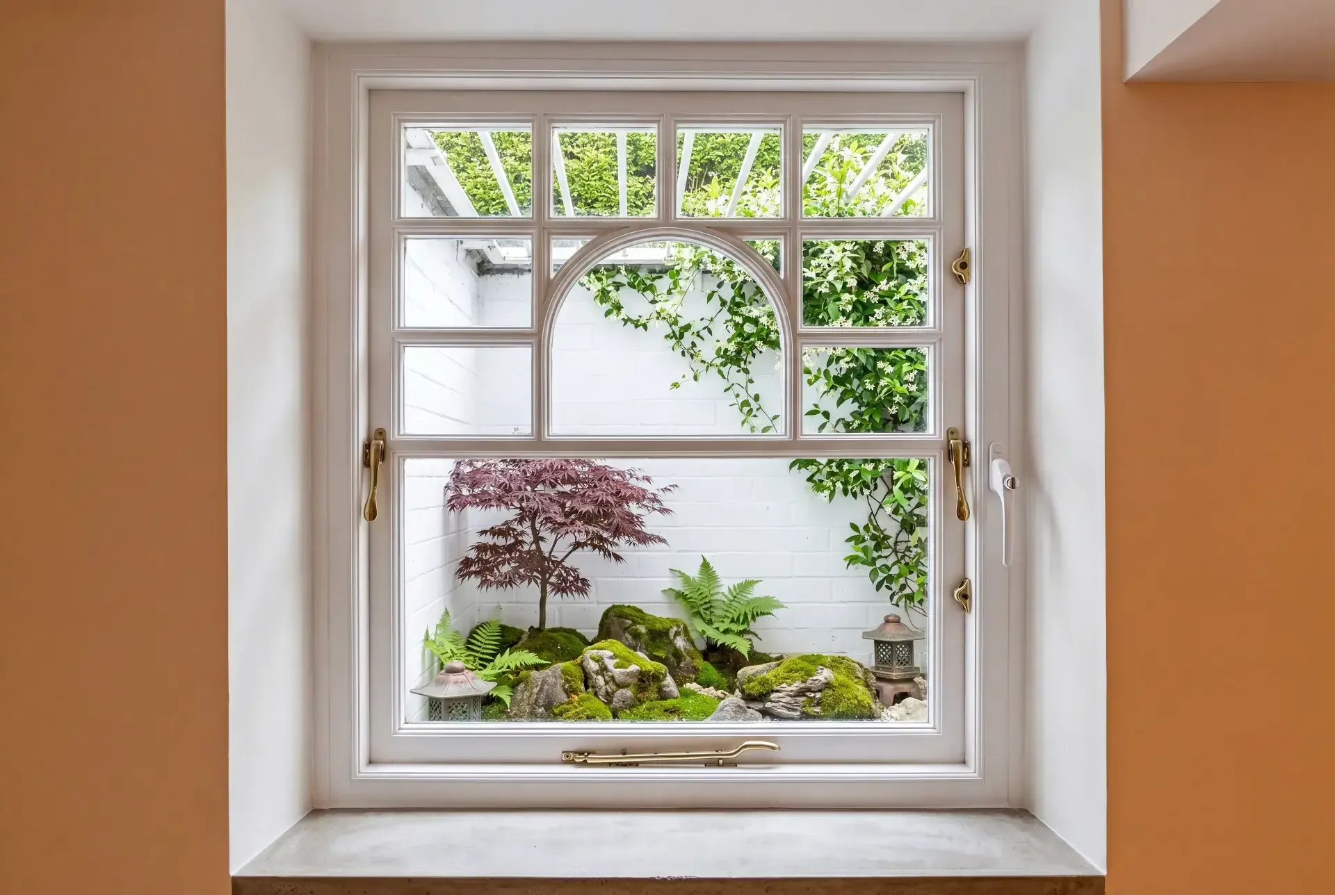 Arched multi-pane heritage window fitted with secondary glazing looking onto a courtyard Japanese garden