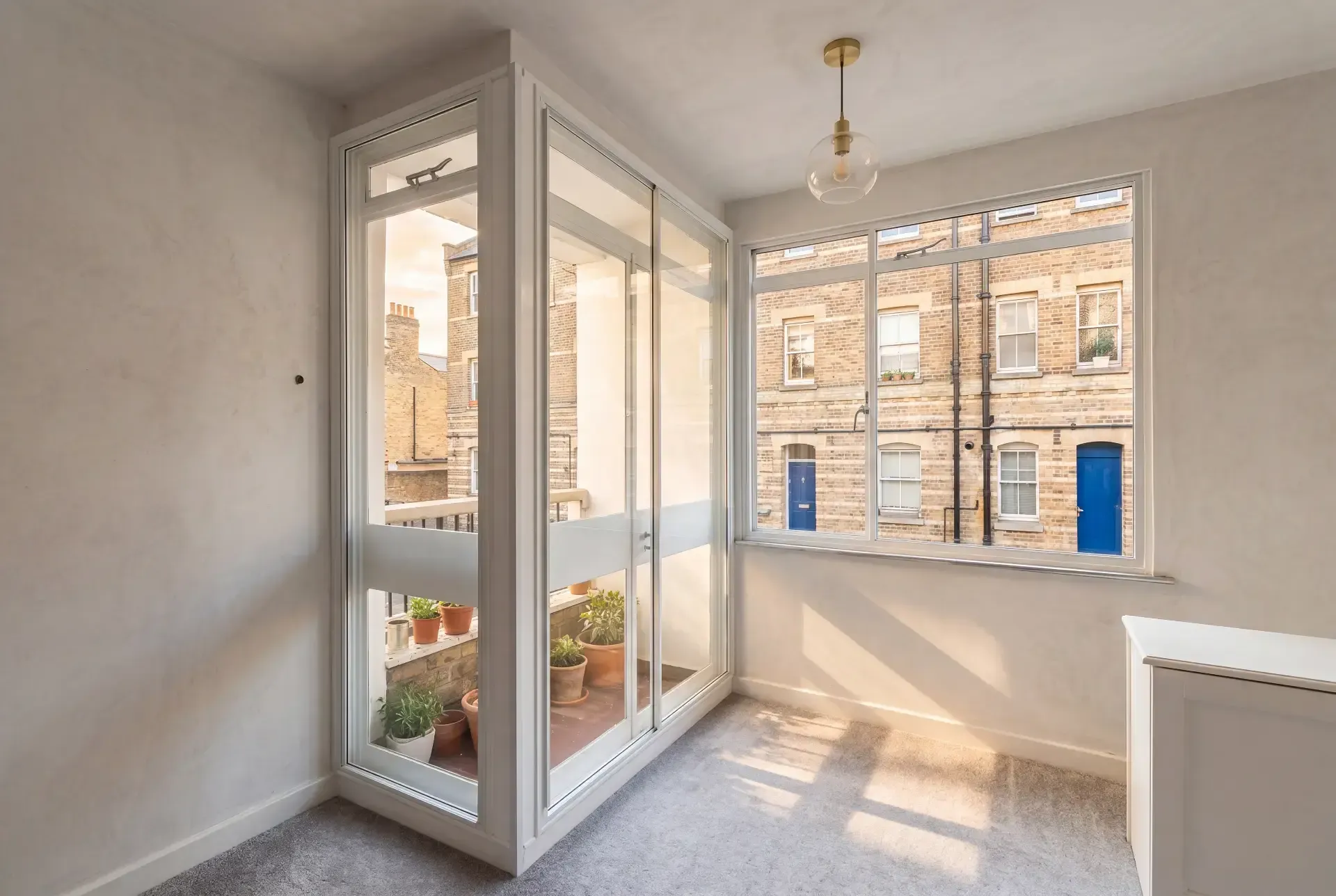 Corner room with a glazed balcony door and wide window fitted with secondary glazing in a Georgian terrace