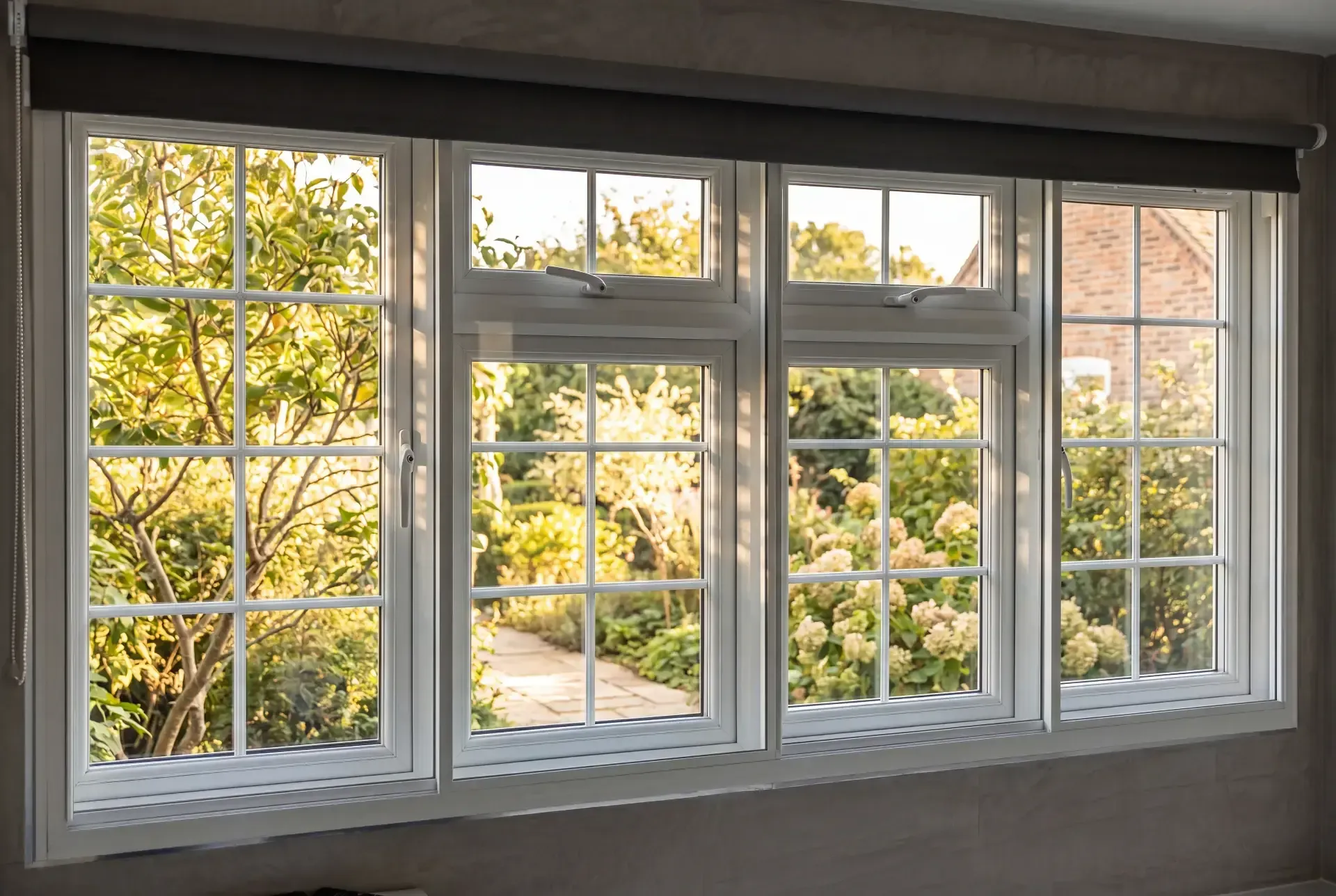 Wide run of four georgian-bar casement windows fitted with secondary glazing overlooking a country garden